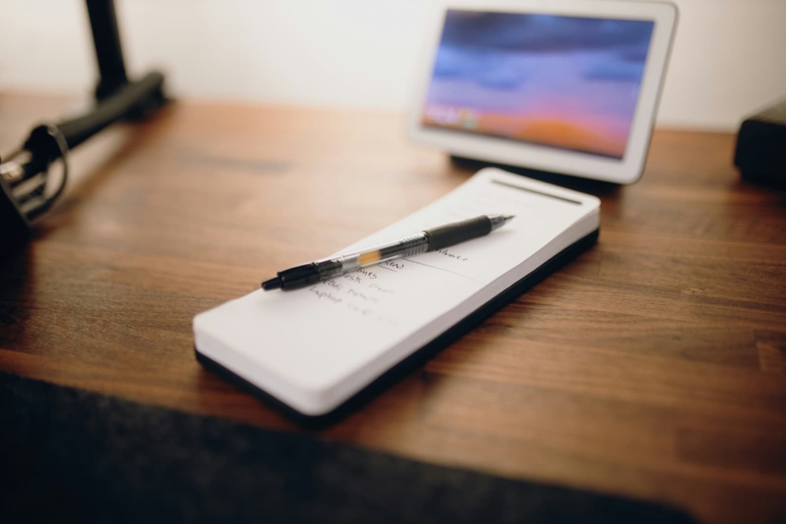 Pen resting on a printed page beside a laptop: the bladder diary PDF and the digital workflow it lives alongside